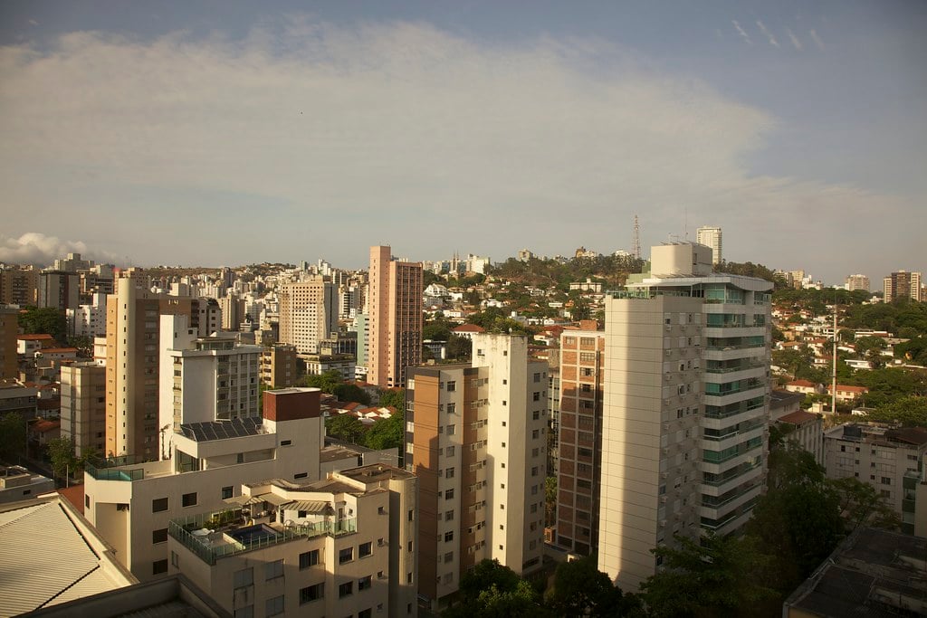 Panorama de Belo Horizonte com skyline e montanhas ao fundo, céu claro