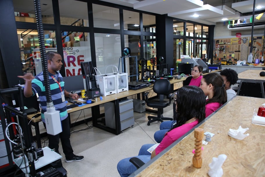 Ambiente de educação profissional com estudantes em laboratório e pedagogo orientando