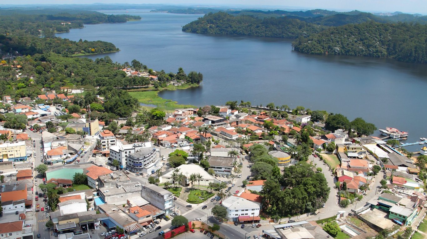Vista aérea de São Bernardo do Campo ao entardecer, com áreas verdes e adensamento urbano