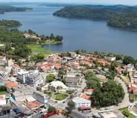Vista aérea de São Bernardo do Campo ao entardecer, mostrando áreas verdes e densa urbanização.