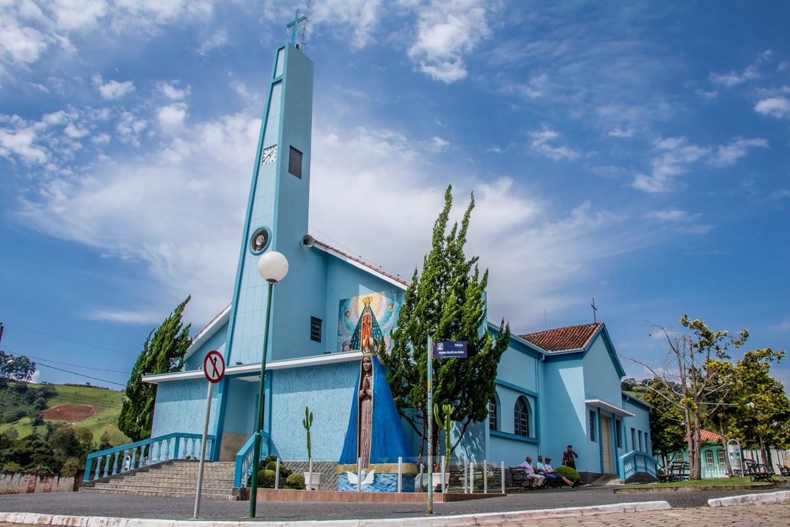 Vista de Tocos do Moji MG, com igreja matriz e entorno urbano em dia ensolarado