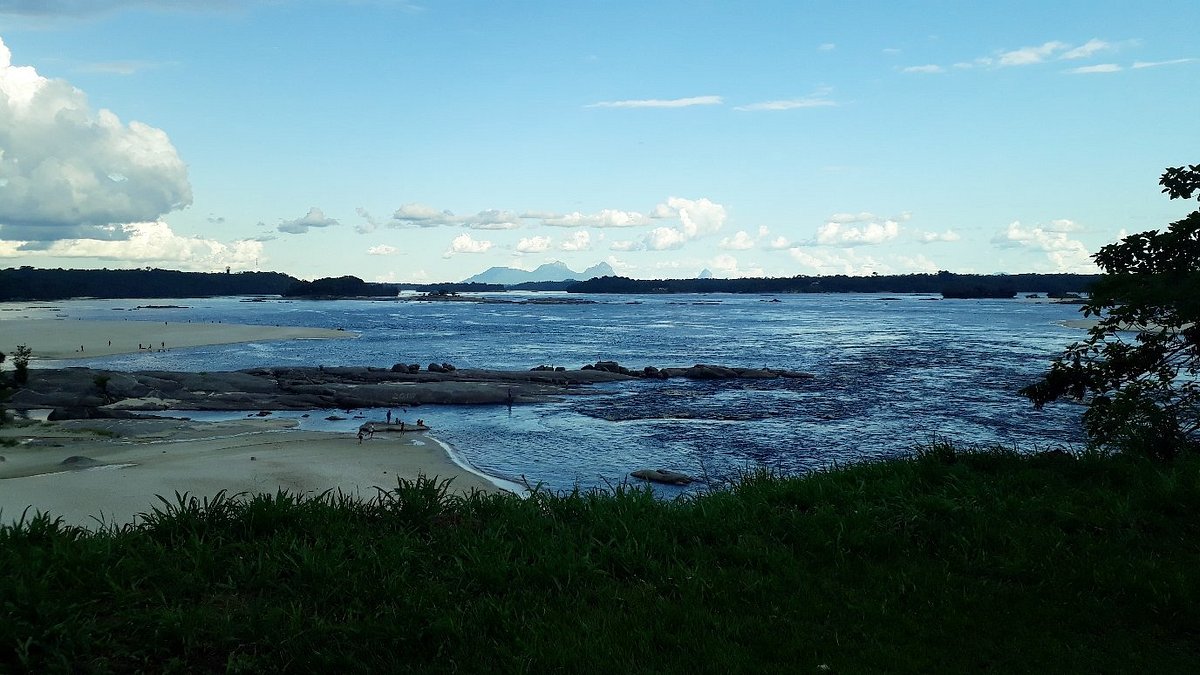 Entardecer no rio com montanhas ao fundo, representando o Alto Rio Negro