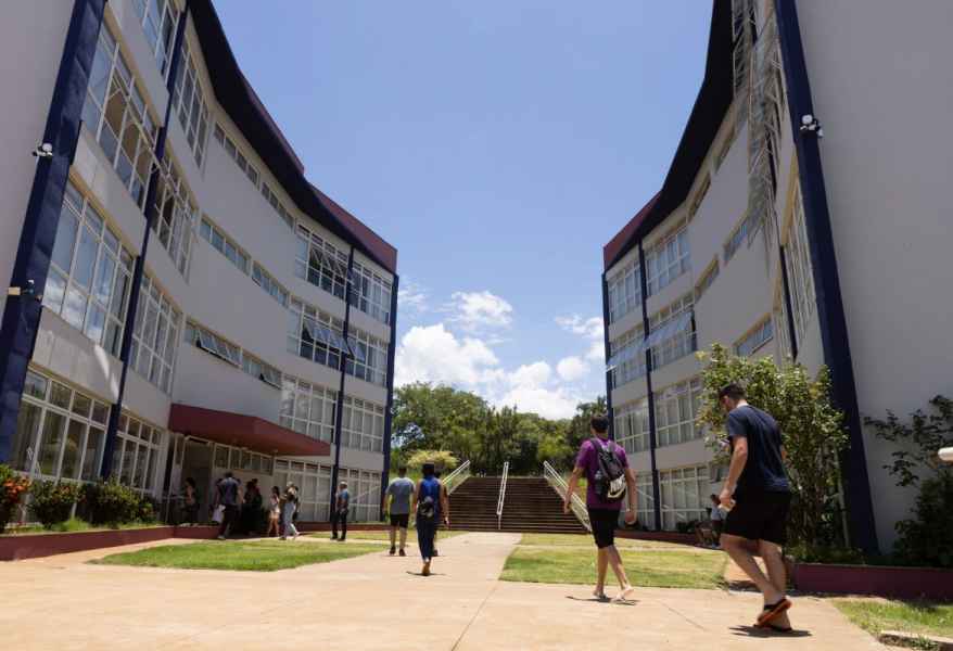 Fachada da UEMG Unidade Passos, com prédios e circulação de alunos