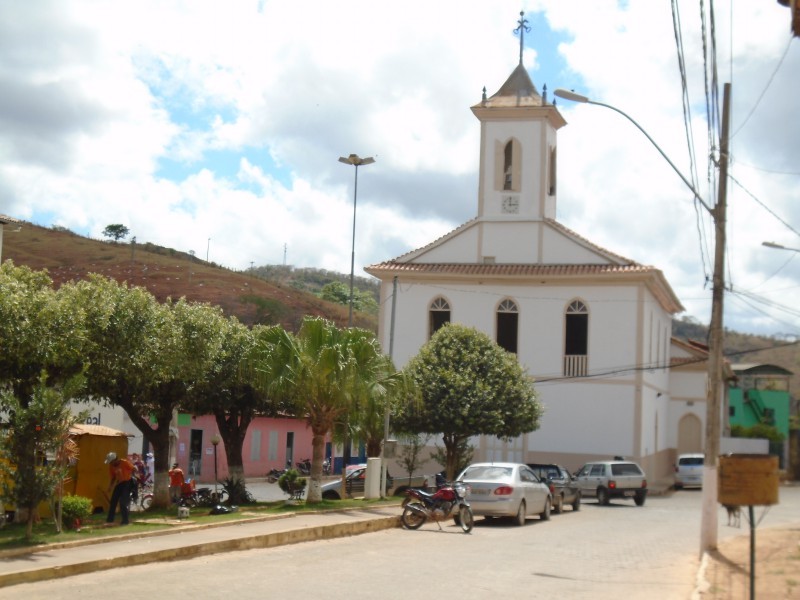Vista urbana de cidade do interior de Minas Gerais, com igreja e árvores ao fundo