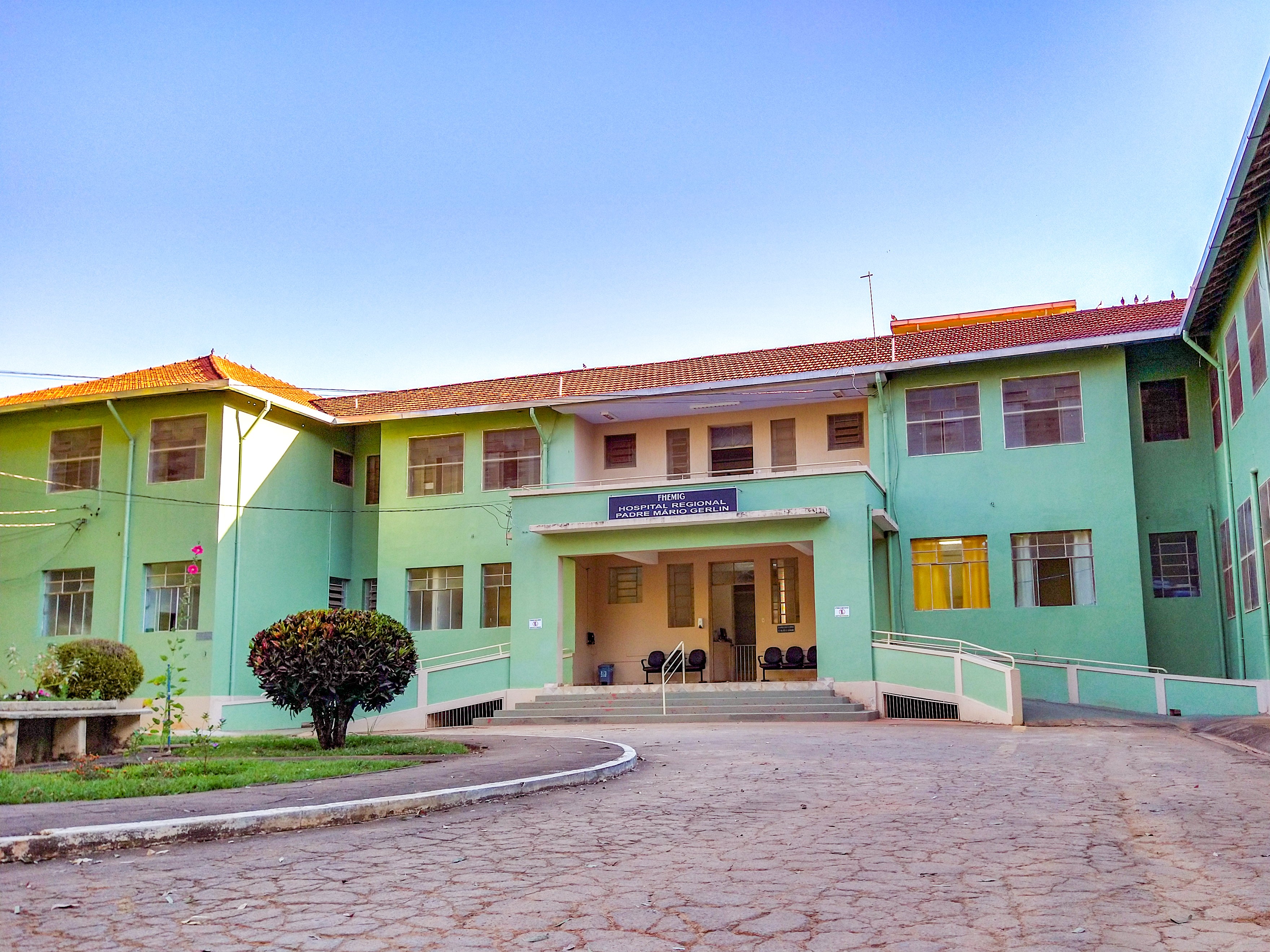 Fachada de hospital público em Minas Gerais, com jardim e acesso principal visíveis