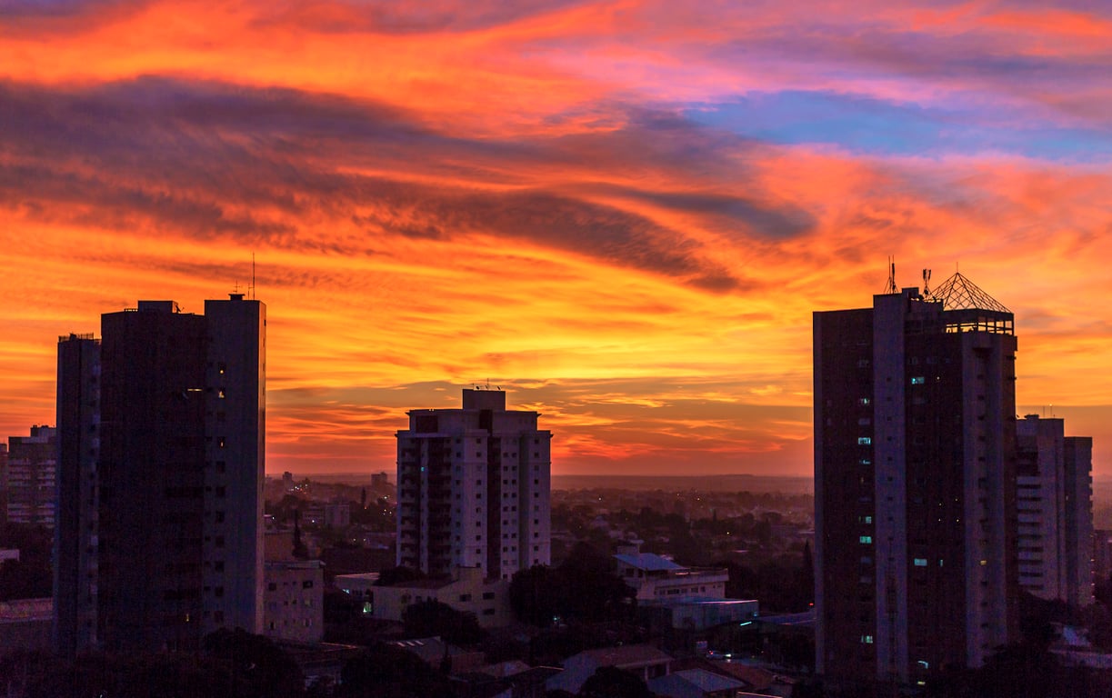 Horizonte urbano de Cascavel ao pôr do sol, com prédios e áreas verdes
