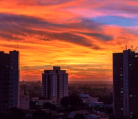 Horizonte urbano de Cascavel ao pôr do sol, com prédios e áreas verdes