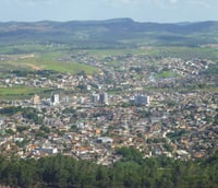 Vista aérea de Itabira MG, com área urbana e morros ao fundo.