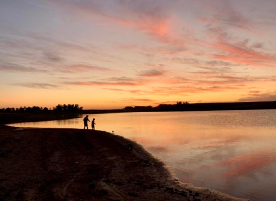 Entardecer no interior capixaba, com lagoa e silhuetas ao fundo