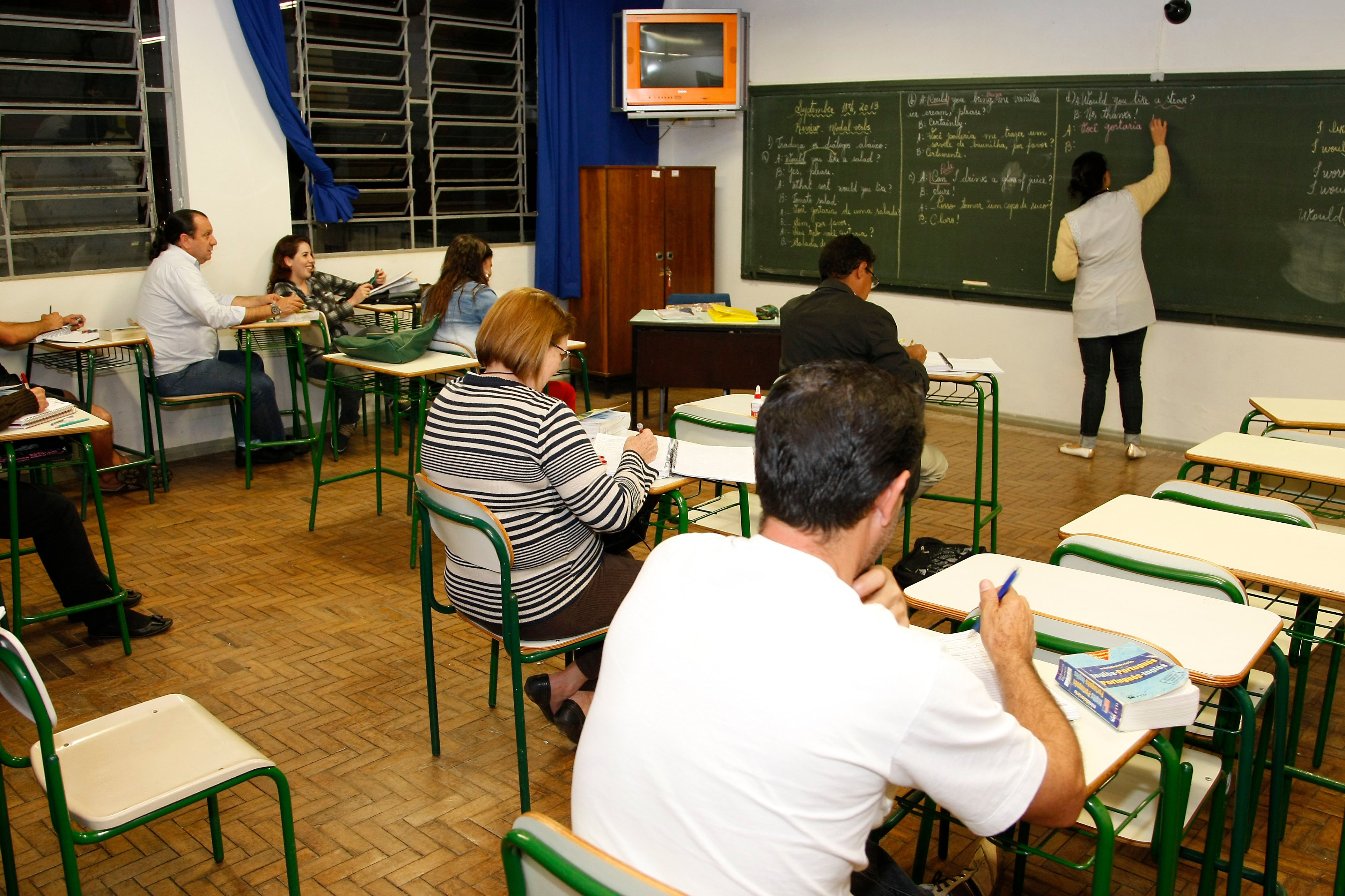 Professor ministra aula para turma universitária adulta, ambiente acadêmico moderno