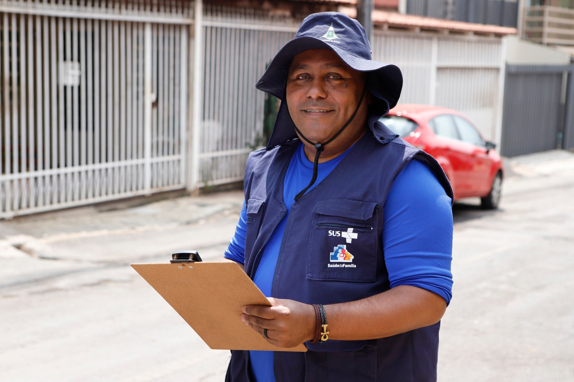 Agente comunitário de saúde em ação com prancheta, em ambiente domiciliar simples