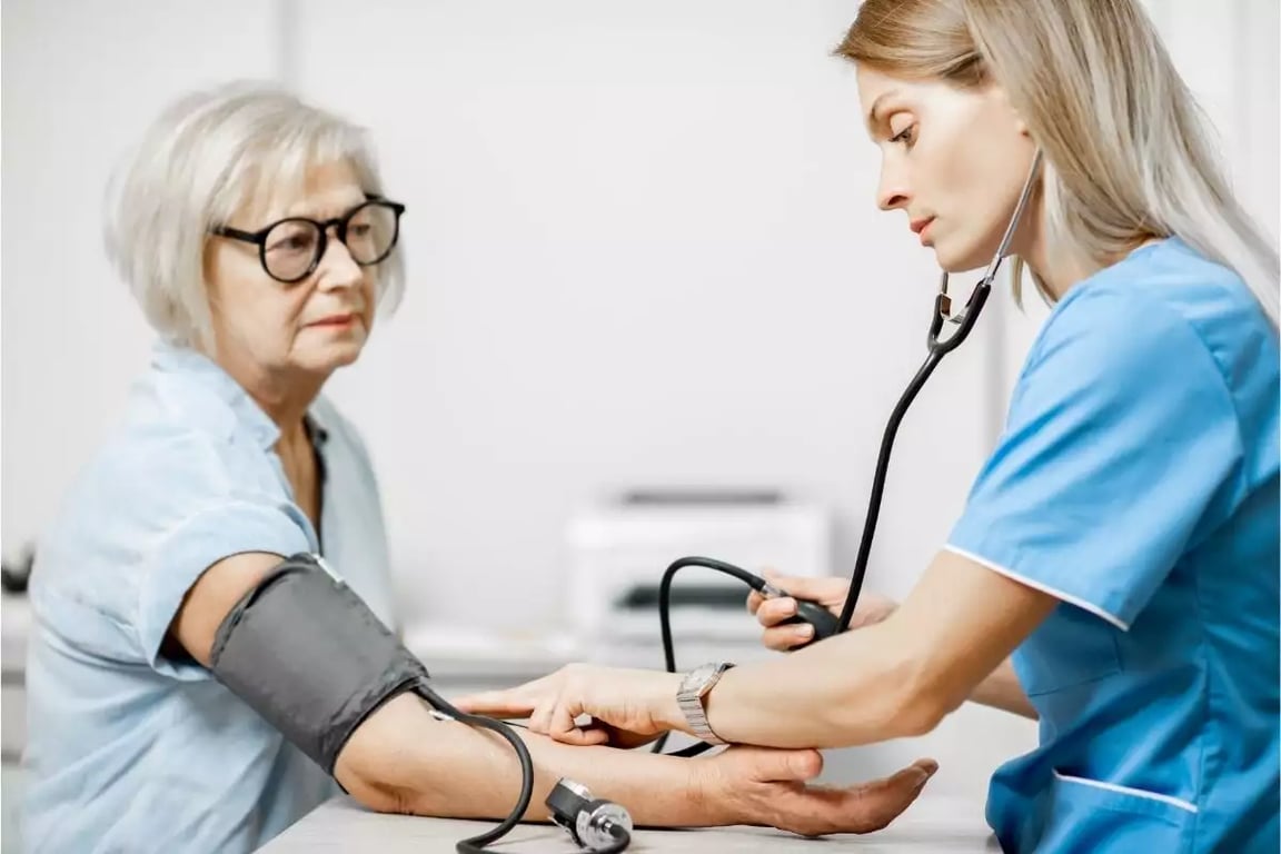 Profissional de saúde atendendo paciente em unidade básica, em ambiente iluminado, com EPI discreto