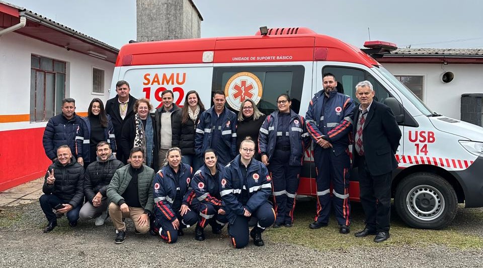 Equipe do SAMU diante de ambulância em área urbana