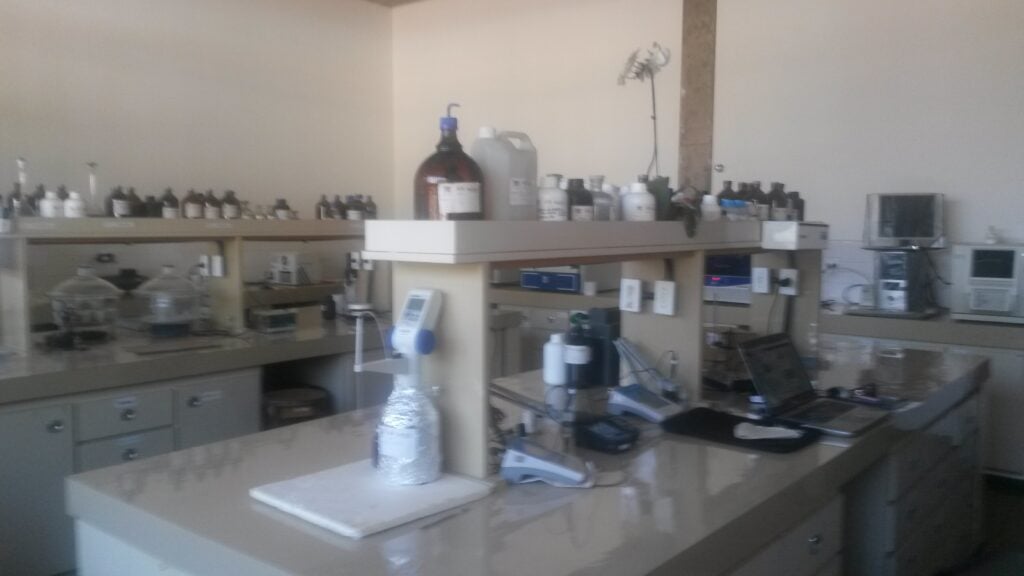 Ambiente acadêmico de engenharia ambiental, com bancada e equipamentos de laboratório