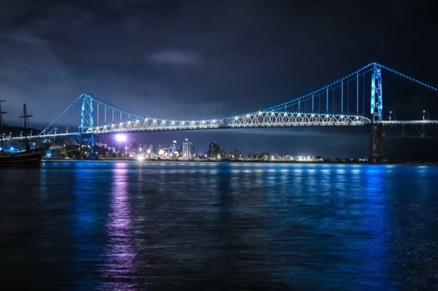 Ponte Hercílio Luz iluminada ao entardecer, cartão-postal de Florianópolis