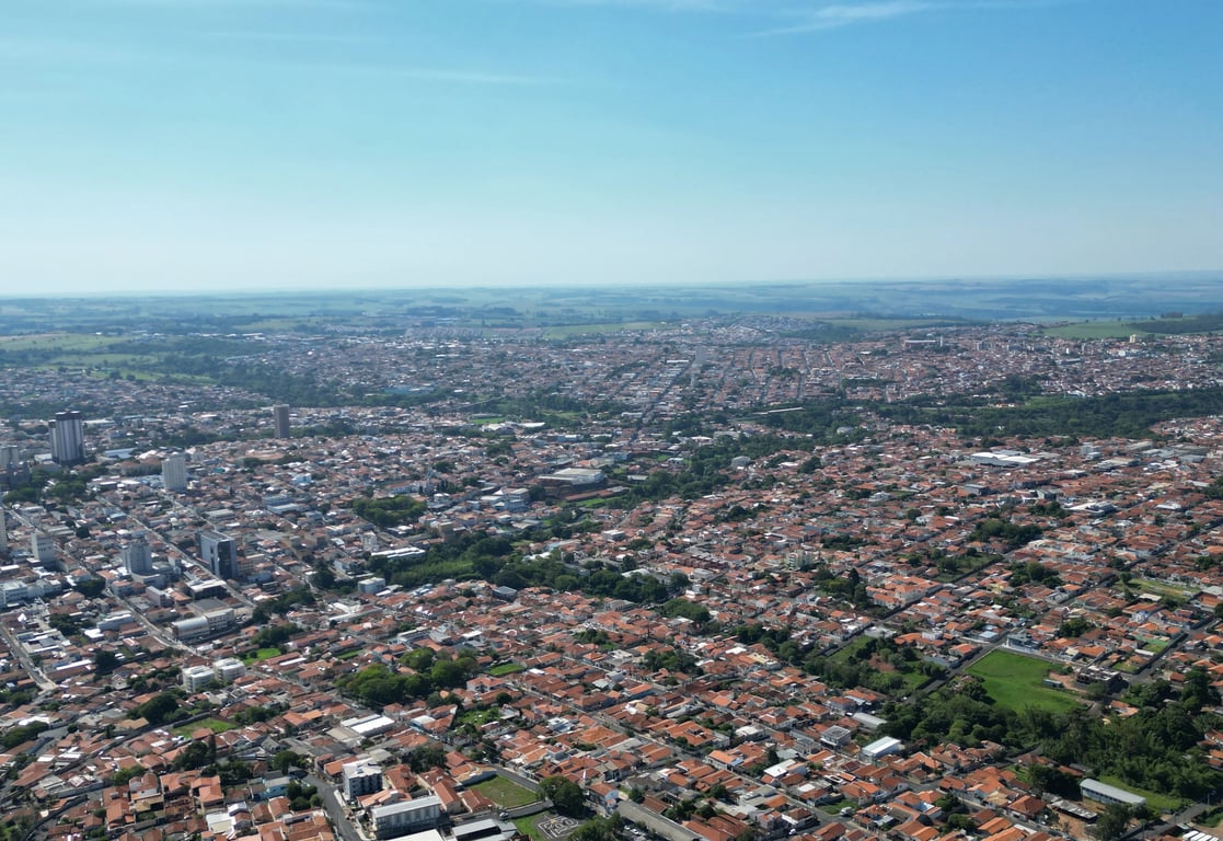 Vista aérea de Botucatu SP, com áreas urbanas e verdes sob céu aberto
