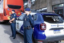 Agentes da Guarda Municipal em patrulhamento diurno, em área urbana.