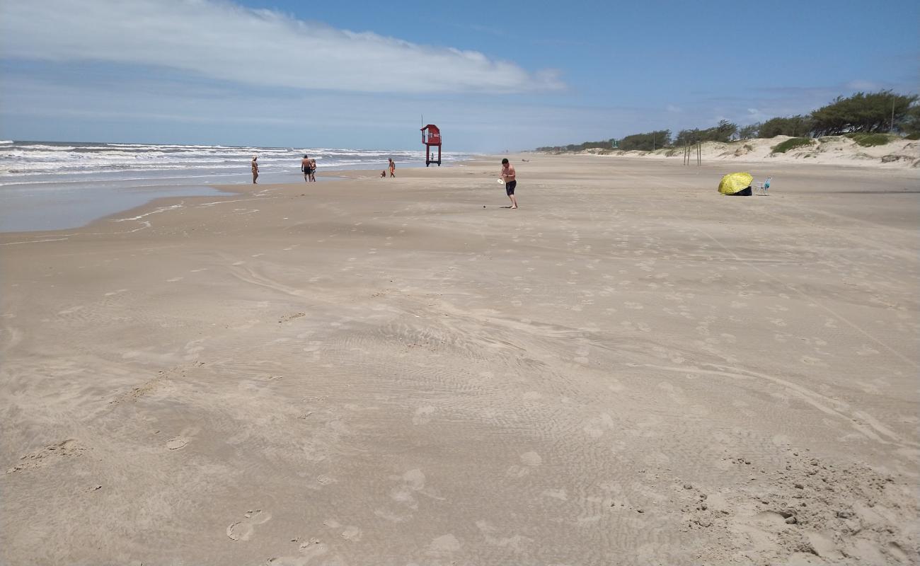 Vista da orla de Tramandaí RS em dia ensolarado, com praia e prédios ao fundo