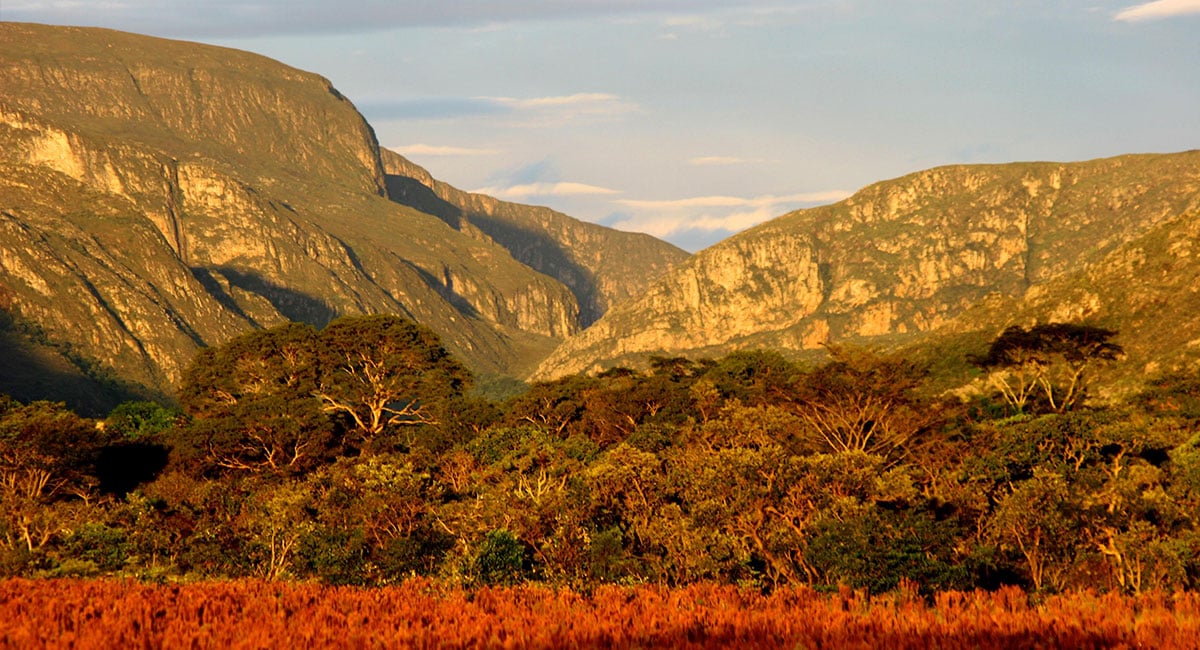 Paisagem da Serra do Cipó ao entardecer, com montanhas e vegetação do cerrado