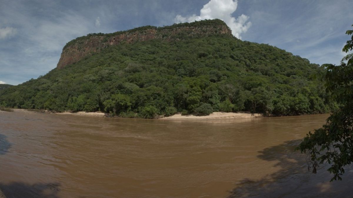 Paisagem do Pantanal ao pôr do sol, com rio sinuoso e vegetação típica, referência a Aquidauana MS