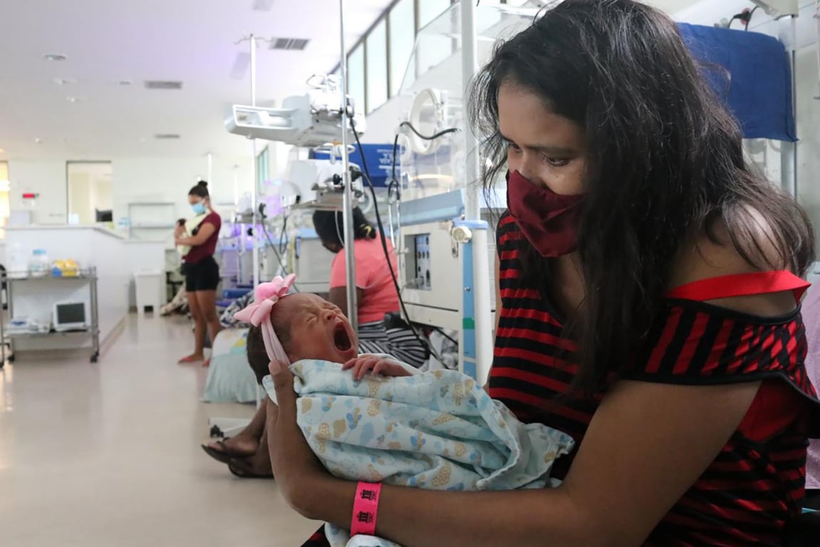 Profissionais de saúde em atendimento a bebê em ambiente hospitalar