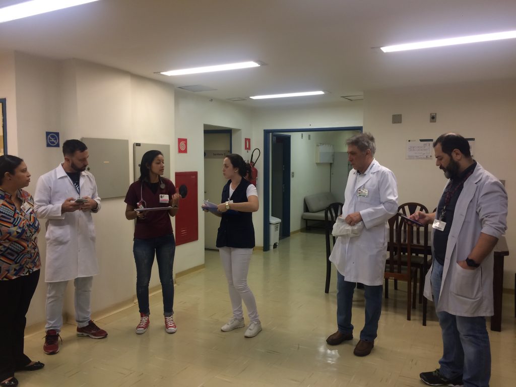 Profissionais de saúde em corredor hospitalar, simbolizando trabalho integrado no SUS