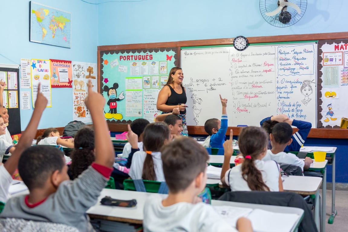Sala de aula em escola pública, ambiente iluminado com carteiras e materiais educativos