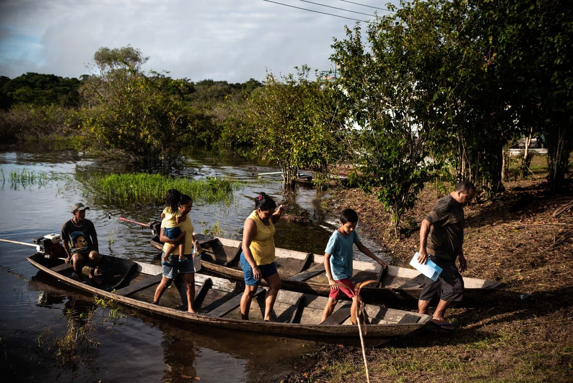 Comunidade ribeirinha em barco durante período de cheia na Amazônia