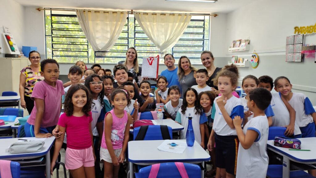 Sala de aula em escola pública, com professor e alunos interagindo