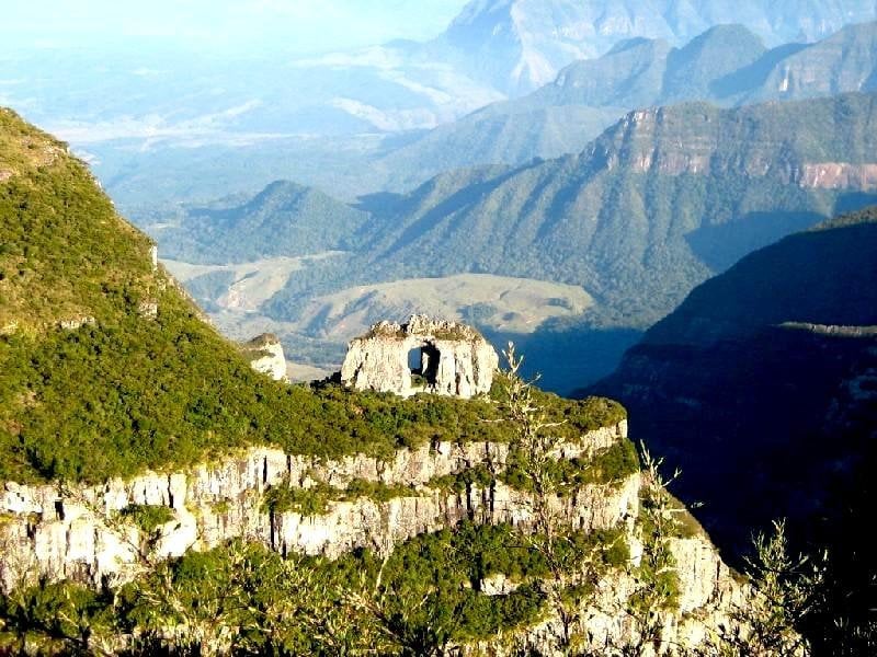 Paisagem da Serra Catarinense ao pôr do sol, com araucárias e montanhas