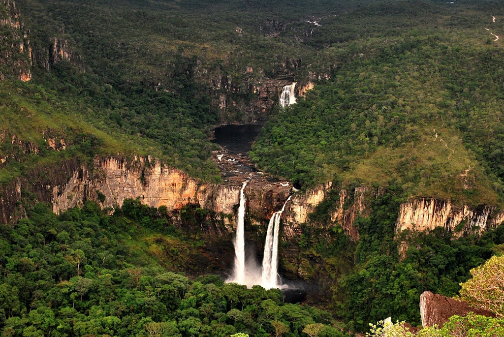 Paisagem do Cerrado em Goiás ao entardecer, com veredas e formações rochosas ao fundo