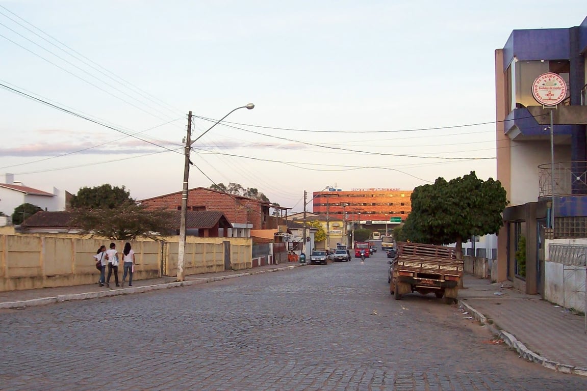 Vista urbana de Euclides da Cunha BA ao entardecer, com praça e avenida movimentadas
