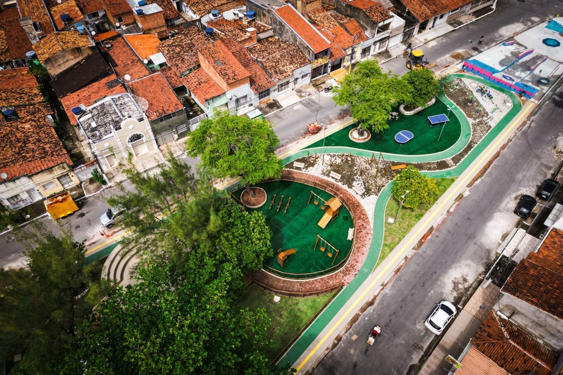 Vista aérea de área urbana no interior de Alagoas, com quadras residenciais e áreas verdes, sob céu aberto.