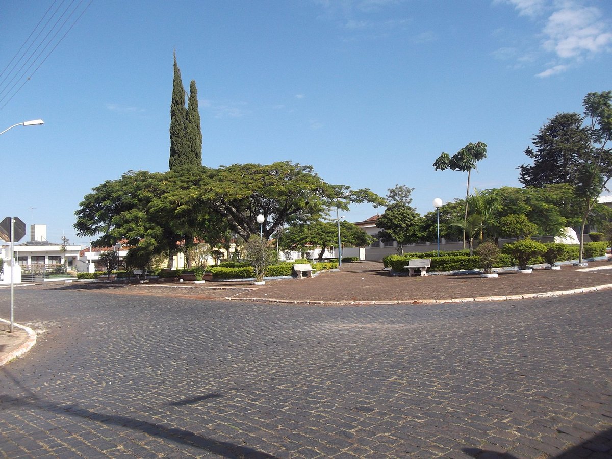 Vista urbana de Siqueira Campos PR — praça arborizada e céu azul