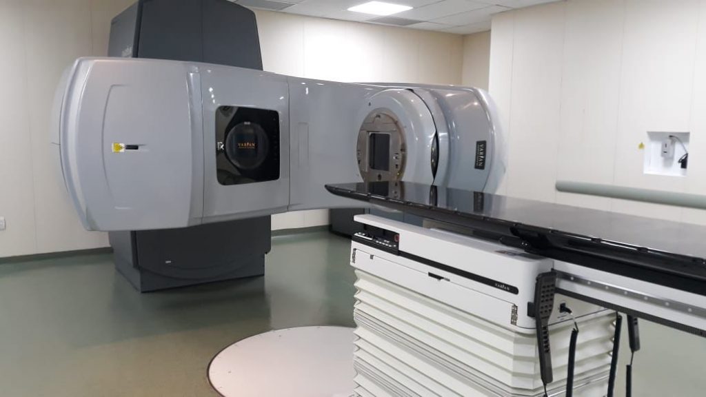 Ambiente de radioterapia com equipamento moderno de grande porte