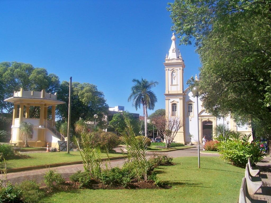Centro urbano de Curvelo, MG, com igreja histórica ao fundo, em dia claro