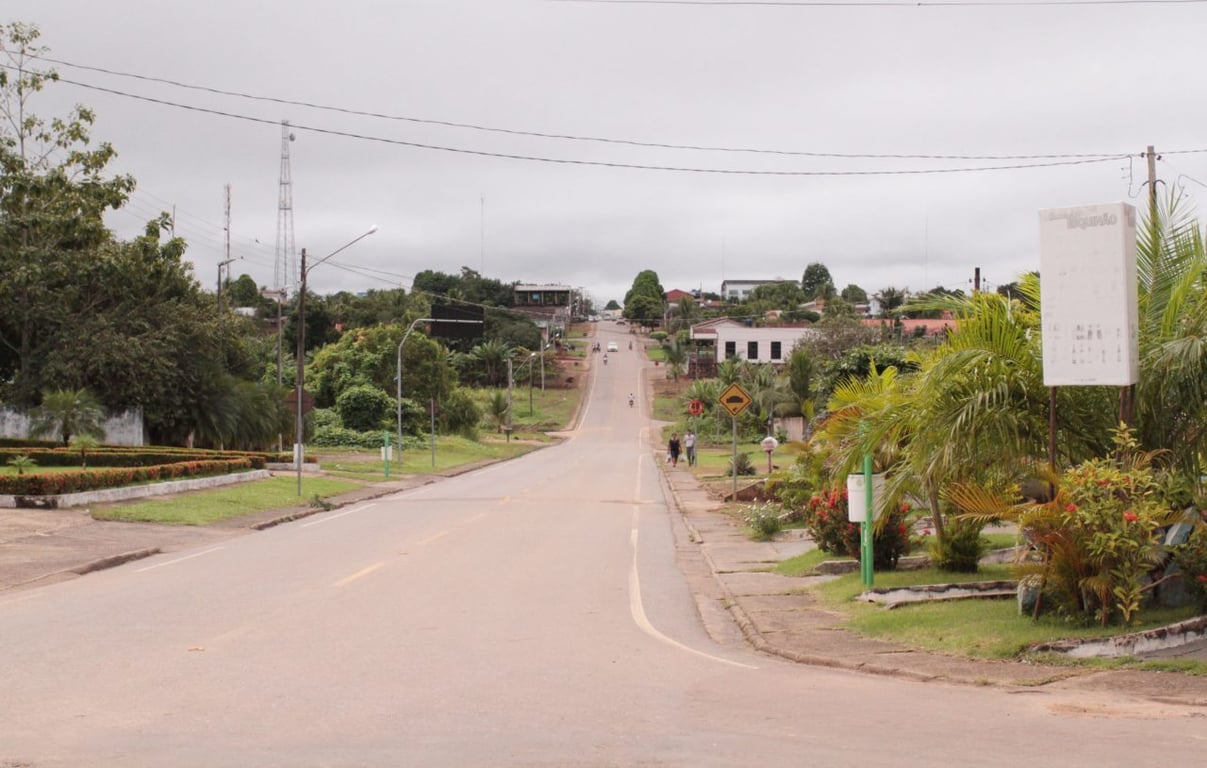 Paisagem do interior de Rondônia, com estrada e áreas rurais, céu nublado