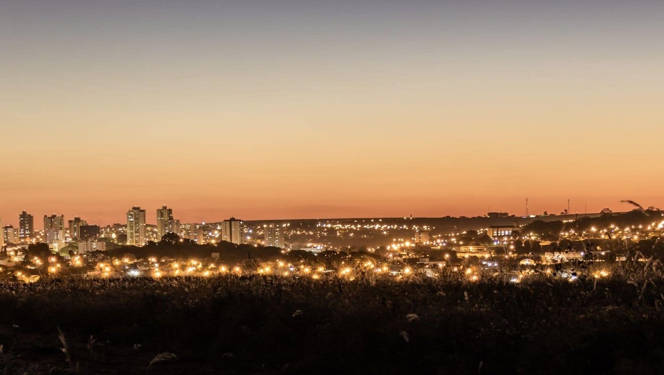 Paisagem urbana ao entardecer em Jaboticabal SP, com praça e edifícios ao fundo