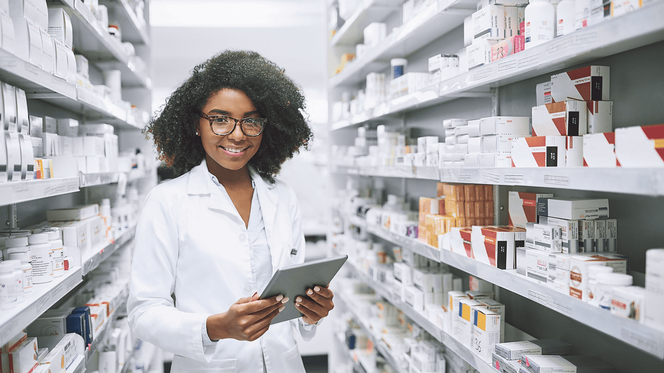Profissional farmacêutica em ambiente de farmácia, com tablet em mãos