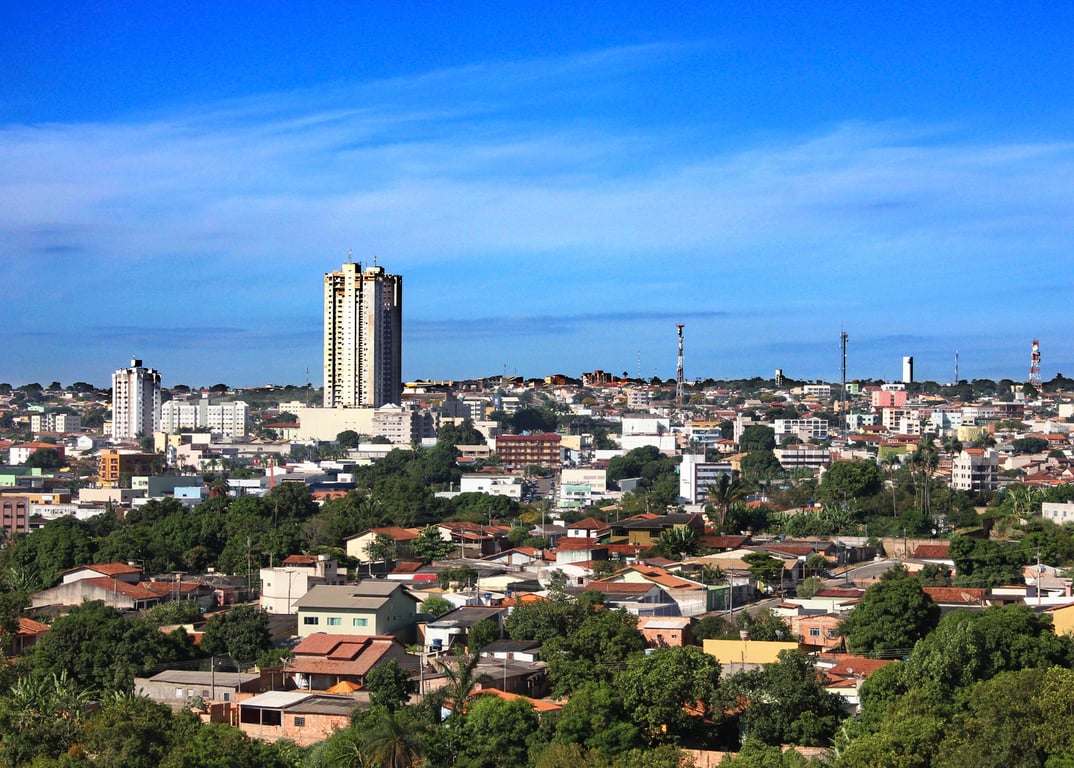 Paisagem urbana de cidade pequena do Centro-Oeste brasileiro, com prédios públicos e ruas arborizadas em dia de céu aberto