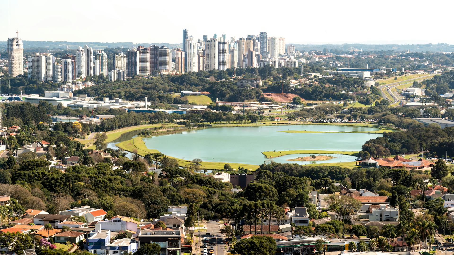 Skyline de Curitiba com áreas verdes ao entardecer