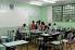 Sala de aula em escola pública com carteiras organizadas e luz natural