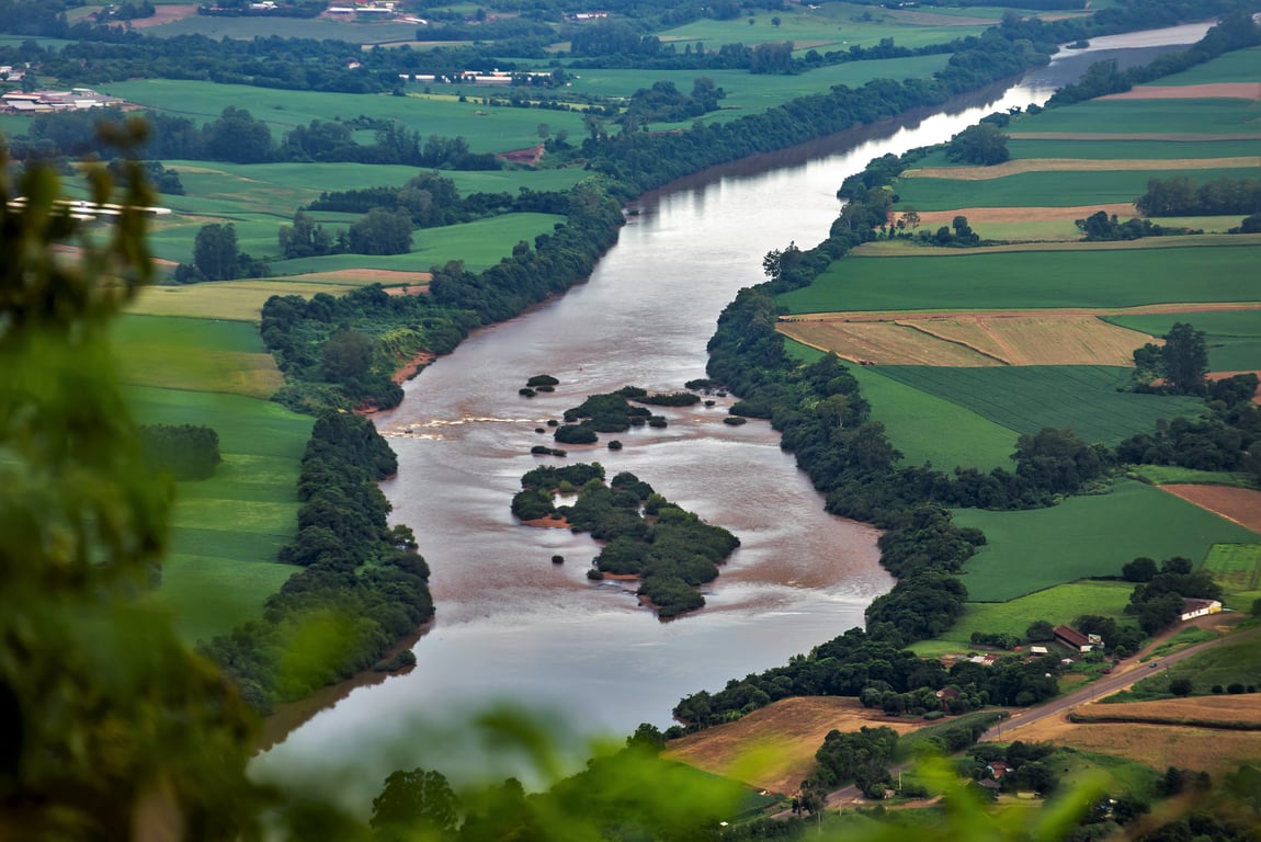 Vista aérea do Rio Taquari com vegetação e campos no entorno, representando o Vale do Taquari
