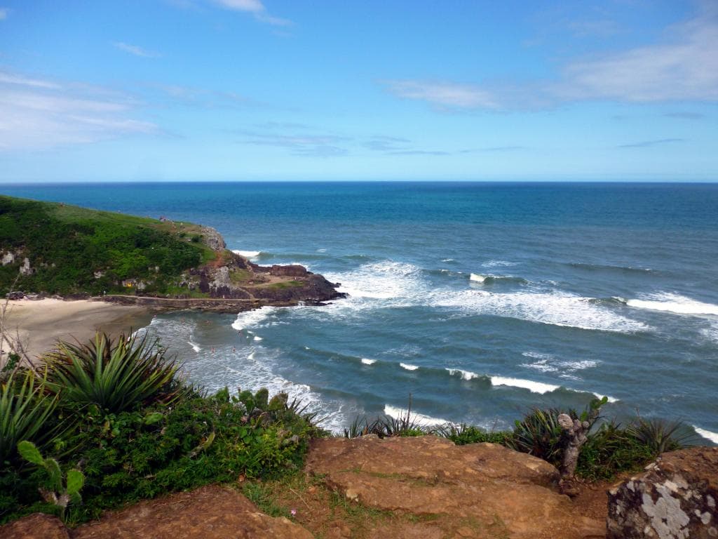 Vista panorâmica de Torres (RS), Praia da Guarita, mar e penhascos ao fundo