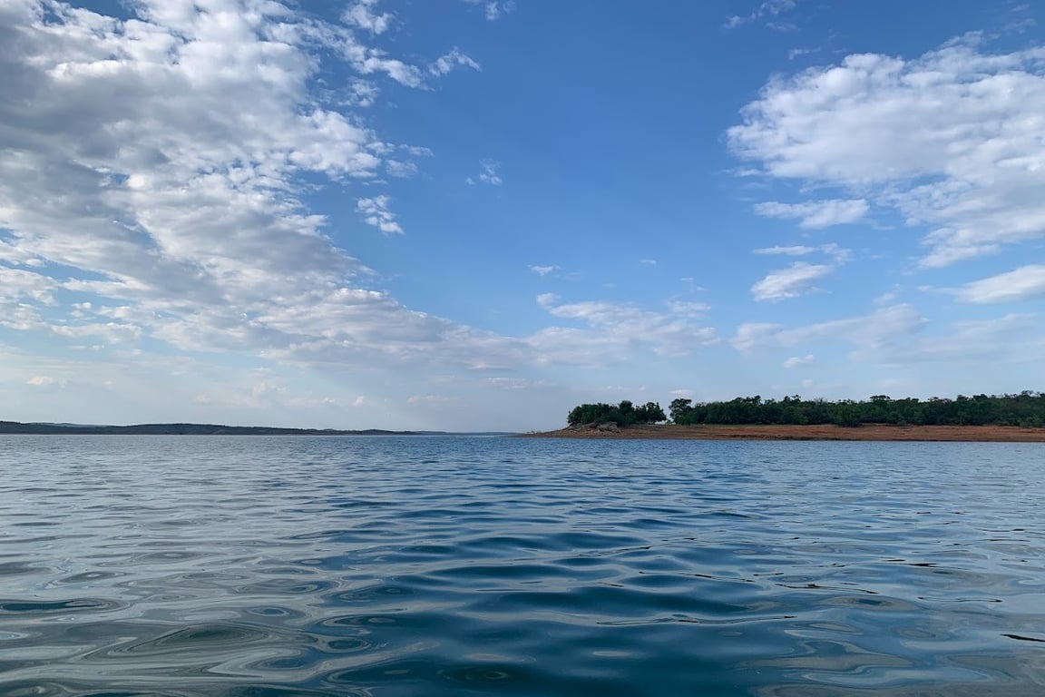 Vista aérea do Lago de Três Marias com céu azul e água clara