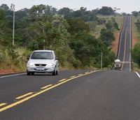 Estrada em região sul-mato-grossense com caminhões e vegetação típica
