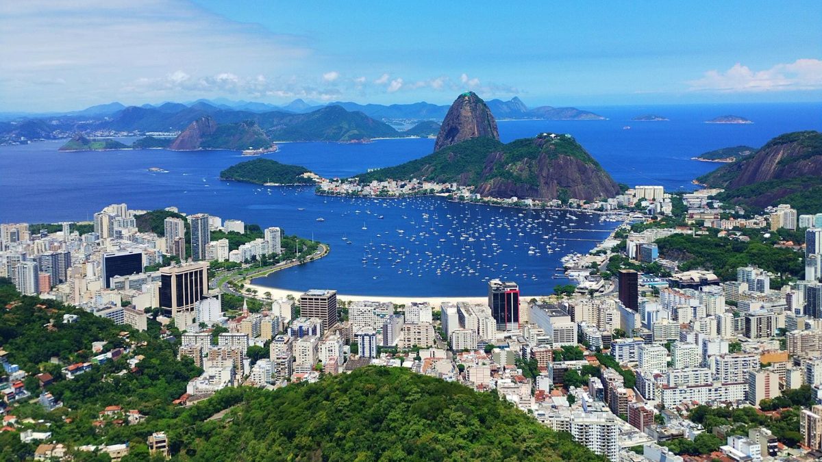 Vista aérea do Centro do Rio de Janeiro, com prédios e a Baía de Guanabara.