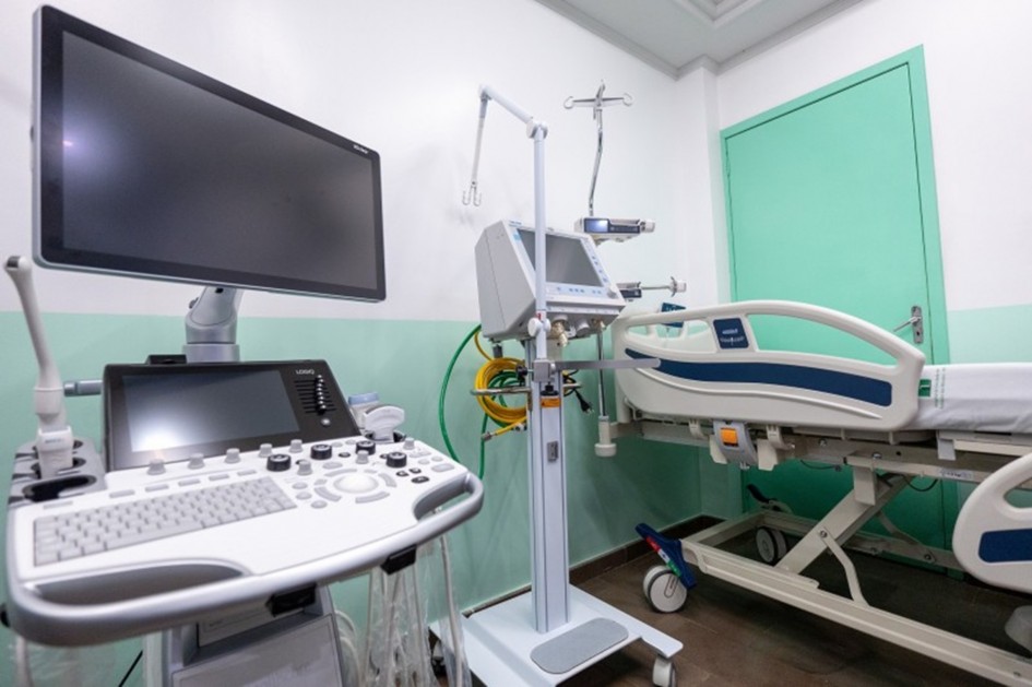 Ambiente hospitalar com leito e equipamentos de monitoramento, em composição horizontal