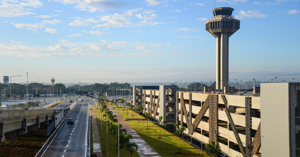 Aeroporto Internacional de Viracopos ao entardecer, com pista e terminal iluminados