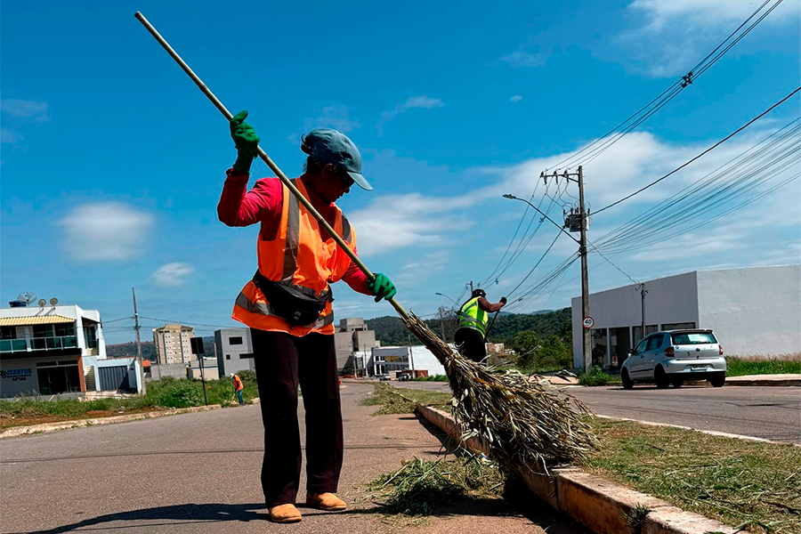 Trabalhadores de manutenção realizando capina em via urbana
